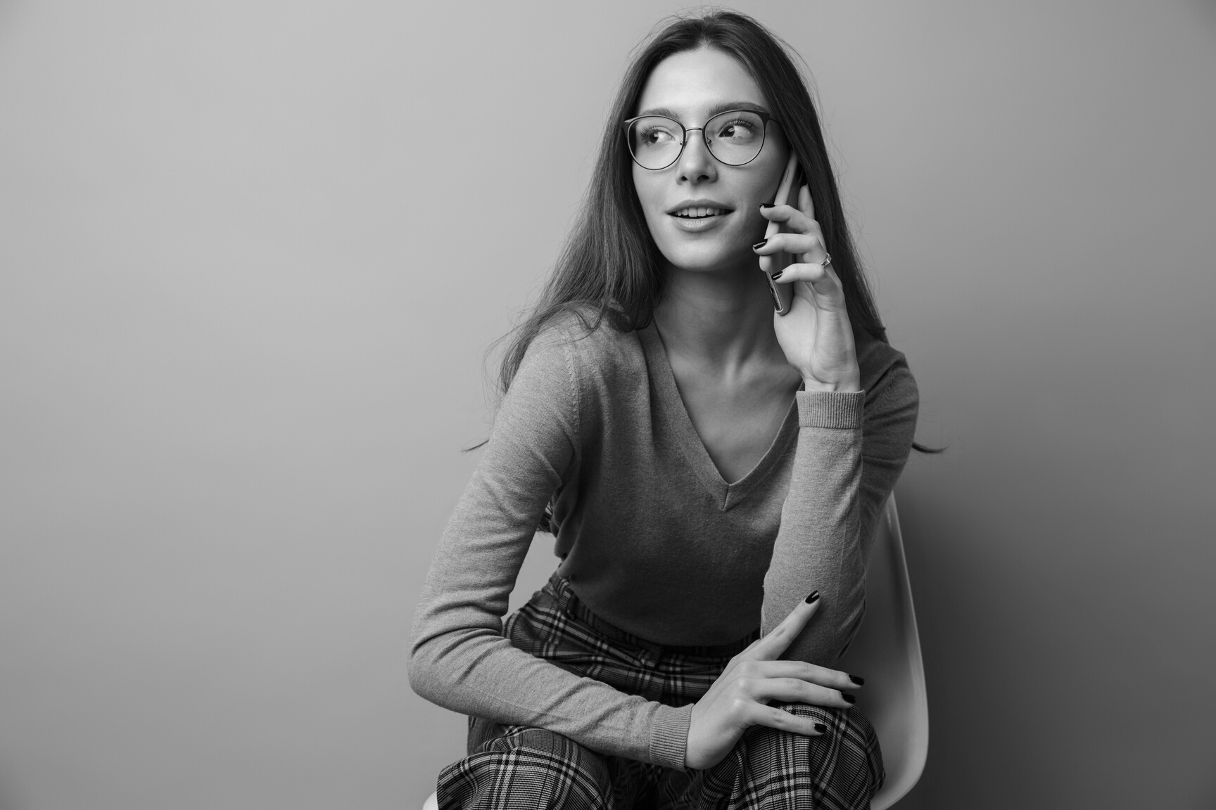 Photo of Pleased Woman Talking on Cellphone and Sitting on Chair